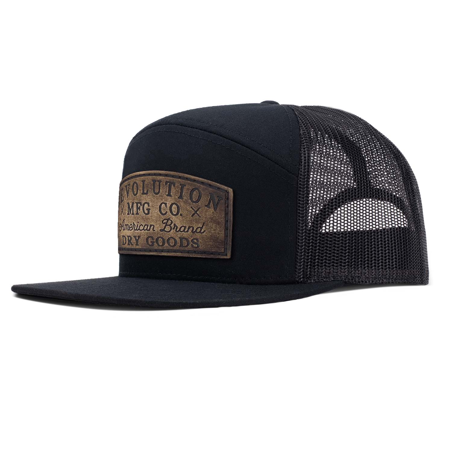 Revolution Mfg black with black mesh 7 panel trucker featuring our original full grain leather Dry Goods patch on the seamless front panel.