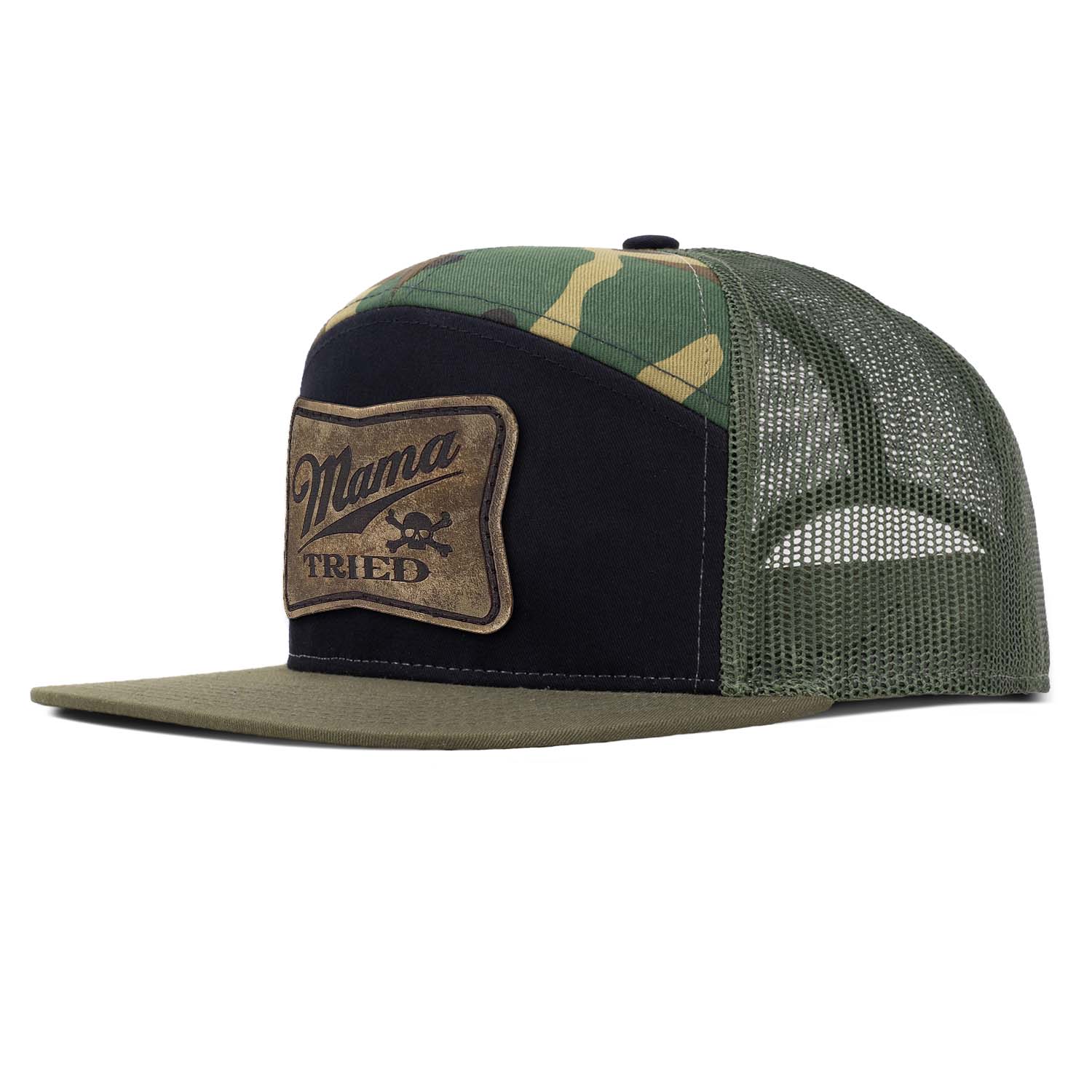 A loden, black, and woodland camo 7 panel trucker hat with loden mesh featuring our full grain leather vintage finish Mama Tried patch stitched on the seamless front panel