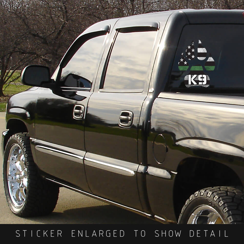 Thin Green Line K9 die cut dog paw decal on the back window of a black truck