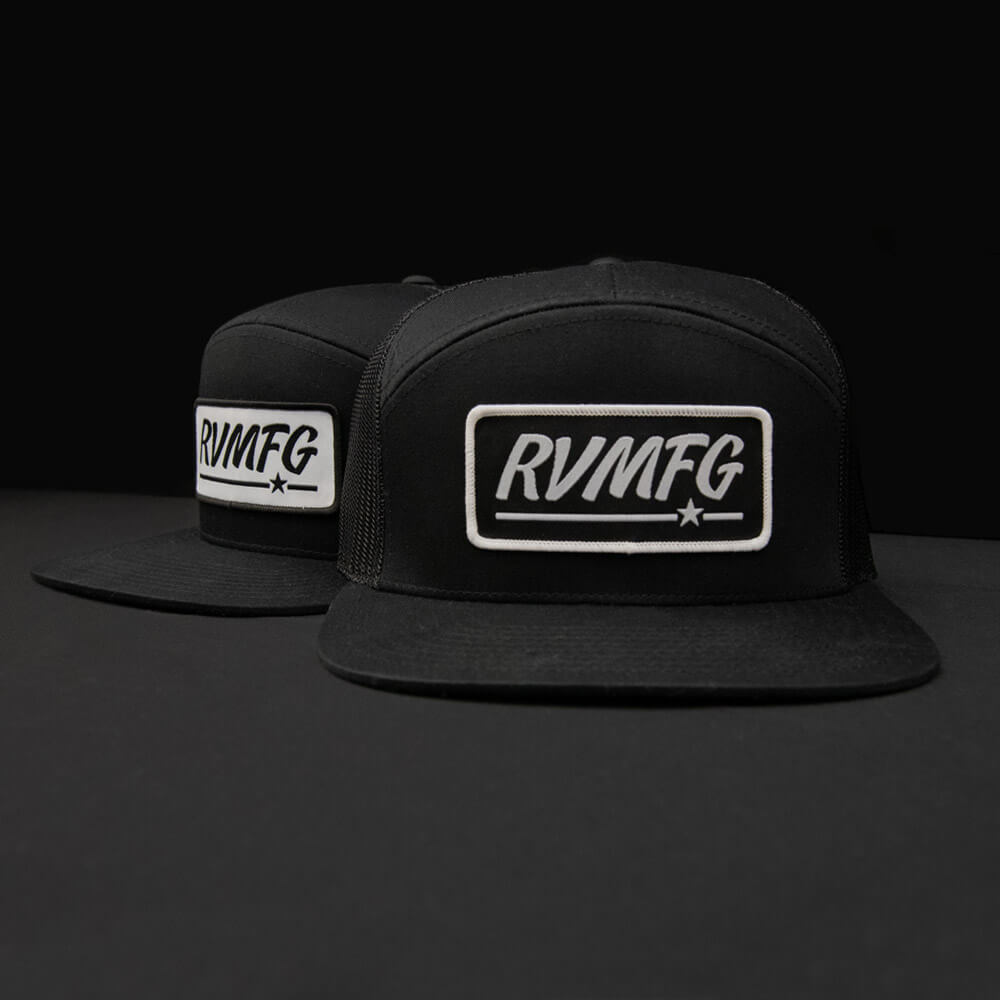 RVMFG black 7 panel trucker hat featuring a custom woven patch available with a black or white background