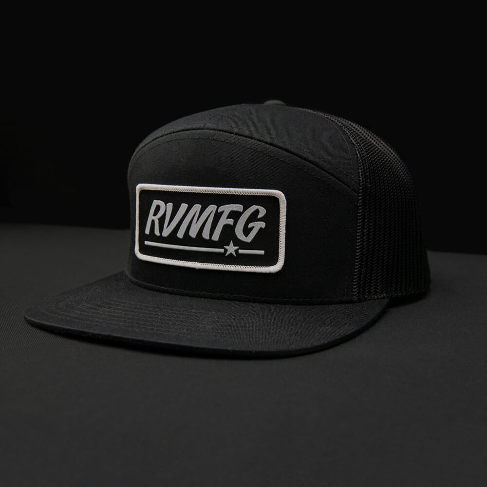 Black 7 panel RVMFG trucker hat with black custom woven patch