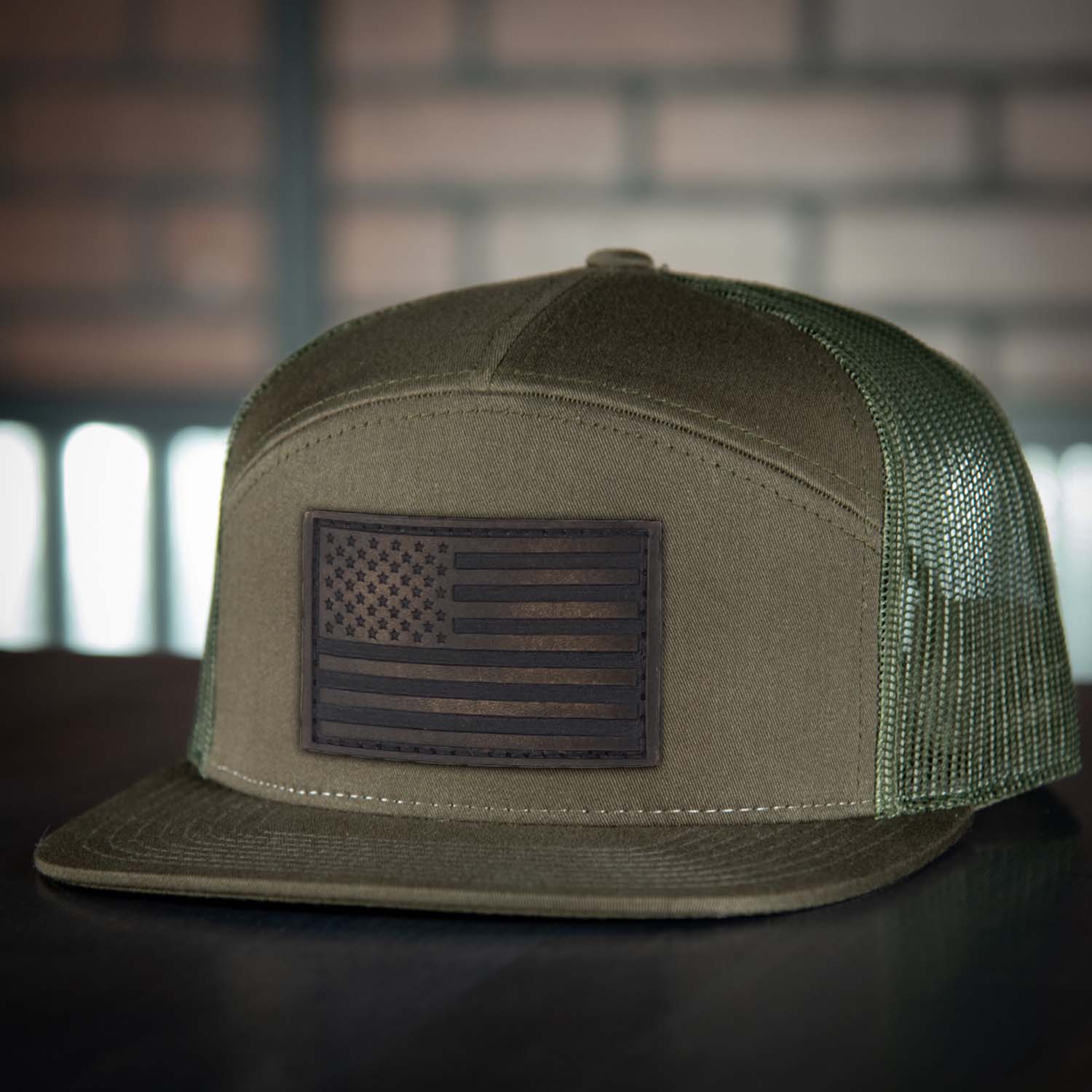 Revolution Mfg full grain leather American flag patch on a 7 panel trucker hat in loden with loden mesh