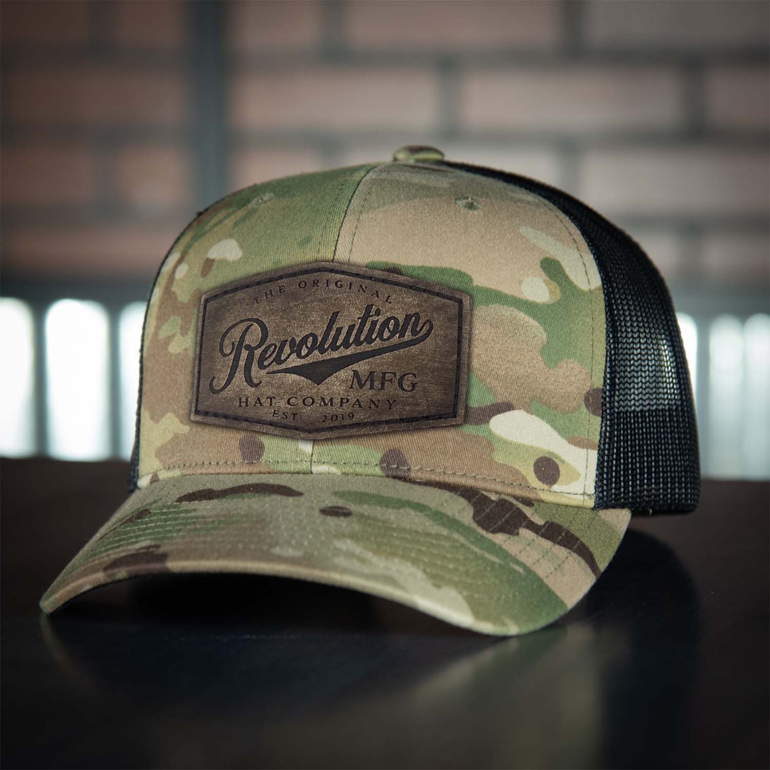 Revolution Hat Co full grain leather patch in a vintage finish on a multicam with black mesh classic trucker hat