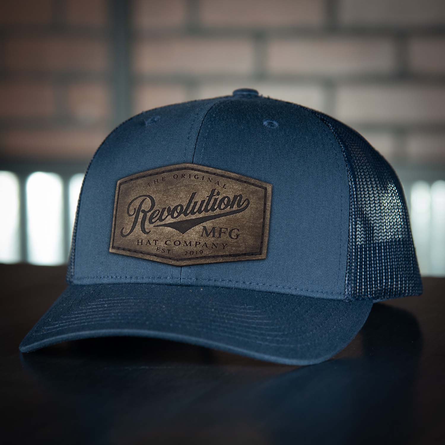 Revolution Hat Co full grain leather patch in a vintage finish on a navy with navy mesh classic trucker hat