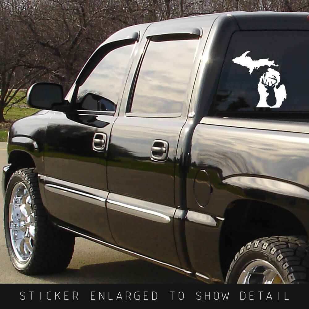 American Made white vinyl Michigan state die cut decal with whitetail deer silhouette cut out shown on back window of black truck